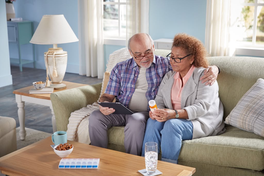 Senior couple reviewing hurricane preparedness information and medications at home